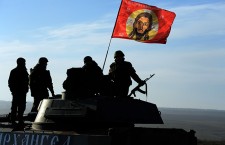 TOPSHOTS
Pro-Russia militants sit next to a flag with the face of Jesus Christ as convoy of 2S1 Gvozdikas (122-mm self-propelled howitzers) takes a break as they move from the frontline near the eastern Ukrainian city of Starobeshevo in Donetsk region, on February 25, 2015.  France, Germany, Russia and Ukraine called on February 24 for a total ceasefire in eastern Ukraine as London announced it was sending troops to train government forces fighting pro-Russian separatists in eastern Ukraine. AFP PHOTO / VASILY MAXIMOVVASILY MAXIMOV/AFP/Getty Images