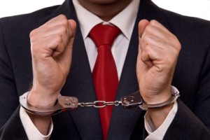 businessman in suit with hands in handcuffs