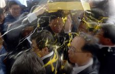 South Korean Prime Minister Hwang Kyo-ahn, bottom center, is shielded by his bodyguards from eggs thrown by residents at Seongju County Office, South Korea, Friday, July 15, 2016. Angry residents in a rural South Korean town have thrown raw eggs and water bottles at the prime minister to protest a plan to deploy a U.S. missile defense system in their neighborhood. (Kang Jong-min/Newsis via AP)