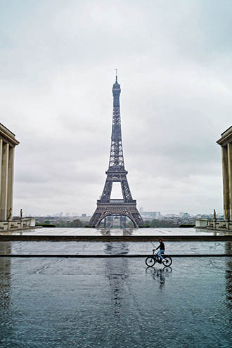 A man rides a bicycle on the deserted Trocadero square in front of the Eiffel Tower during nationwide confinement measures to counter the Covid-19, in Paris, Monday, April 6, 2020. The new coronavirus causes mild or moderate symptoms for most people, but for some, especially older adults and people with existing health problems, it can cause more severe illness or death. (AP Photo/Thibault Camus)