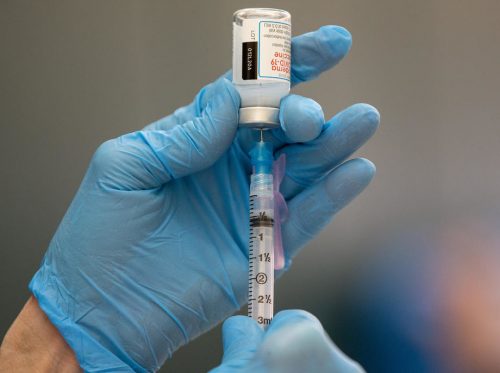 epa08940362 Registered Nurse Connie Gannor prepares doses of a Covid-19 vaccine shot, manufactured by Moderna, at a vaccination center set up in the Rumney Marsh Academy gymnasium in Revere, Massachusetts, USA, 15 January 2021. First responders are part of Phase One of the roll-out of vaccinations in the Commonwealth of Massachusetts.  EPA-EFE/CJ GUNTHER