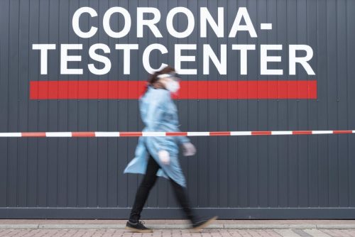 Medical staff Louise Walewski passes the front of a Corona test center in Dresden, Germany, DFriday, April 23, 2021. People in Germany will have to prepare for new Corona restrictions starting this weekend. (Sebastian Kahnert/dpa via AP)