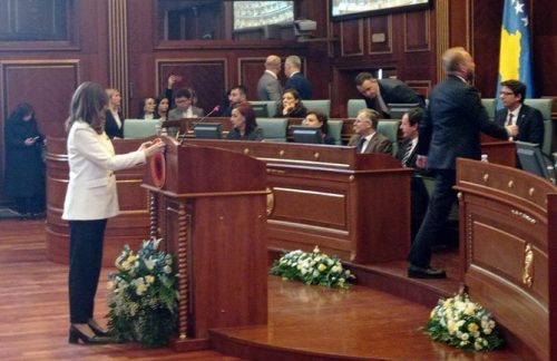 Посланица Демократске партије Косова Ганимете Мусљиу поставља амблем УЧК на говорницу