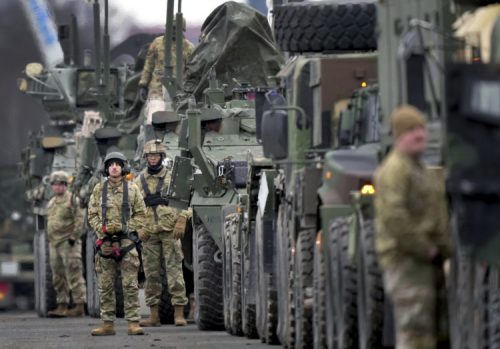 FILE - Soldiers of the 2nd Cavalry Regiment line up vehicles at the military airfield in Vilseck, Germany, Feb. 9, 2022 as they prepare for their deployment to Romania in support NATO allies and demonstrate U.S. commitment to NATO Article V. German Chancellor Olaf Scholz planning to travel to Ukraine and Russia on Monday, Feb. 14, 2022,  in an effort to help defuse escalating tensions as Western intelligence officials warn that a Russian invasion of Ukraine is increasingly imminent. (AP Photo/Michael Probst, File)