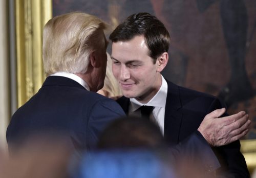US President Donald Trump (L) congratulates his son-in-law and senior advisor Jared Kushner after the swearing-in of senior staff in the East Room of the White House on January 22, 2017 in Washington, DC. (Photo by MANDEL NGAN / AFP)